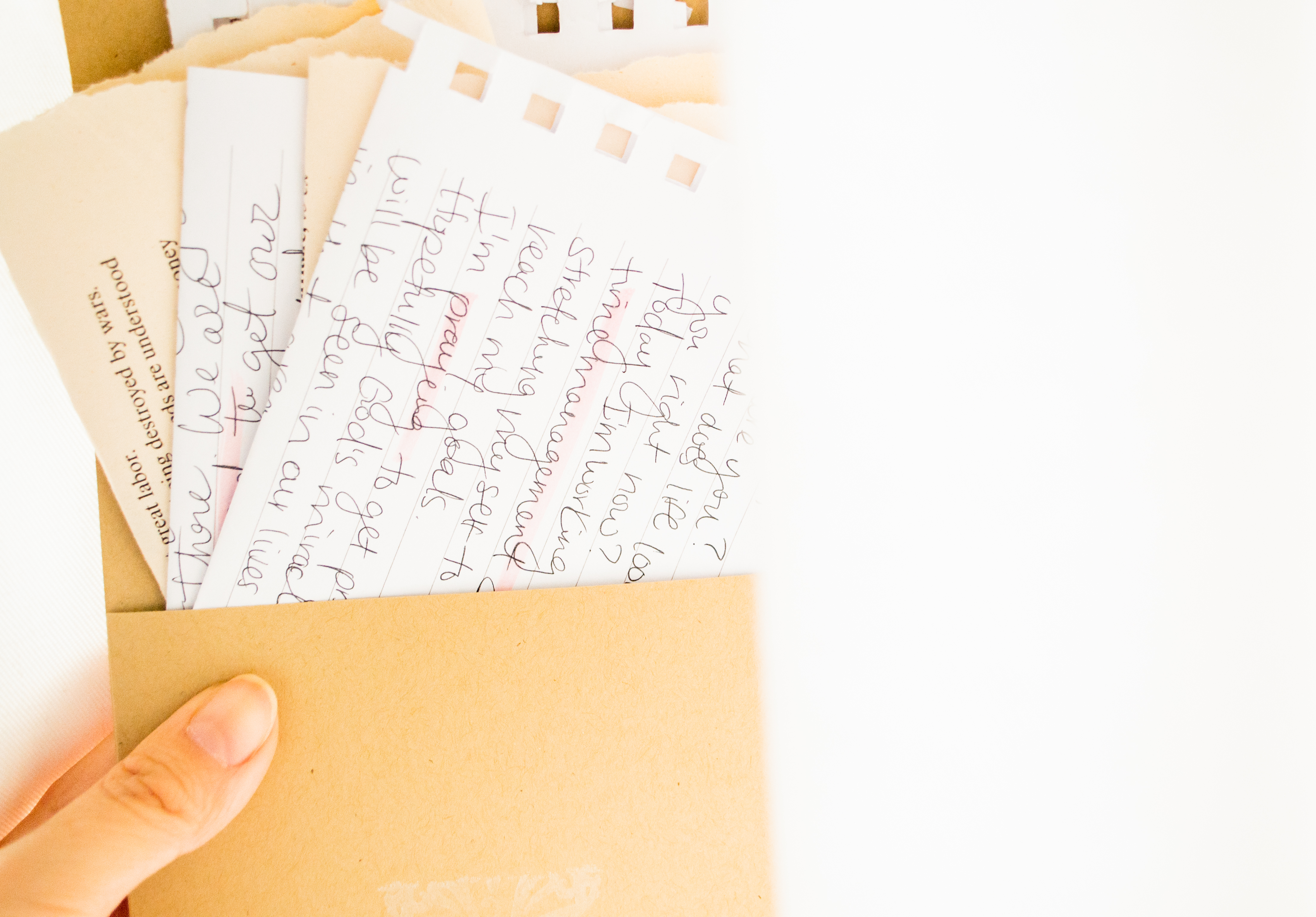 Holding an envelope with hand written note on a white fabric with lots of light